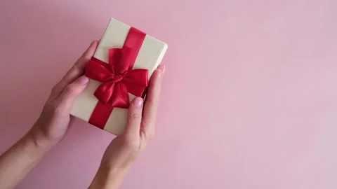 Hand put gift box on pink background and removes Stock Footage 234313322
