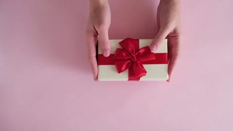 Hand put gift box on pink background and removes Stock Footage 234313323