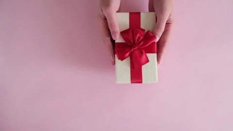 Hand put gift box on pink background and removes Stock Footage 234313345