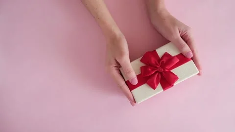 Hand put gift box on pink background and removes Stock Footage 234313364