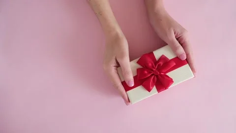 Hand put gift box on pink background and removes Stock Footage 234313365