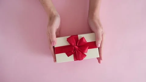 Hand put gift box on pink background and removes Stock Footage 234313383