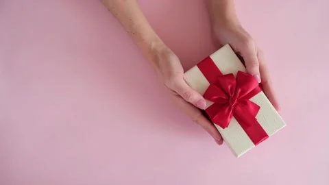 Hand put gift box on pink background and removes Stock Footage 234313385