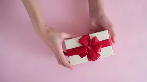 Hand put gift box on pink background and removes Stock Footage 234313407