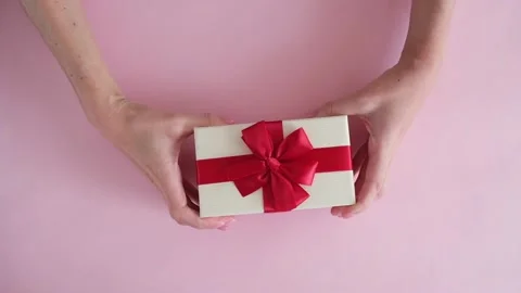 Hand put gift box on pink background and removes Stock Footage 234313408