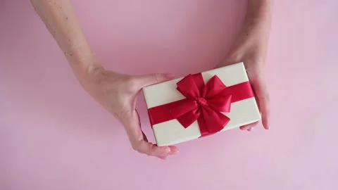 Hand put gift box on pink background and removes Stock Footage 234313442