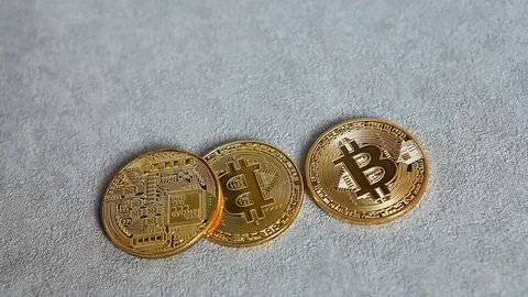 Hand put golden Bitcoin on gray background, cryptocurrency concept 動画素材 83821607