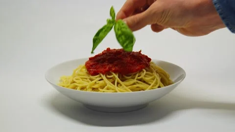 Hand put green basil on italian tomato sauce pasta spaghetti. Stock Footage 164873038