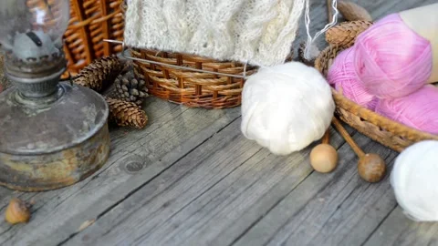 Hand put knitting work on basket and put white ball of wool beside basket Stock-Footage 118255277