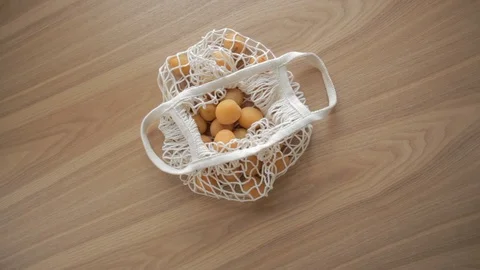 Hand put on mesh organic string bag with fruits on wooden table.ECO, zero waste Vídeo Stock 114899353