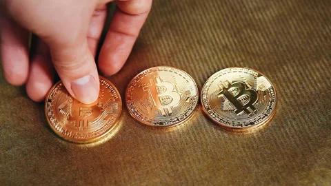 Hand put one more golden bitcoin, cryptocurrency concept with coins Stockbeeldmateriaal 85639451