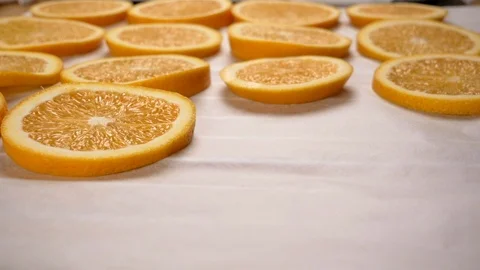 Hand put orange slices on baking paper. Close up. Video stock 116545498