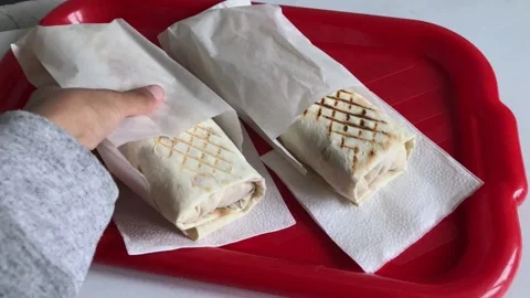 Hand put shawarma close-up. Tasty snack serving Stock Footage 146024089