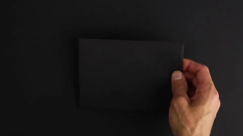 Hand put strange black envelope mysterious letter on black background, take back Video stock 138890820