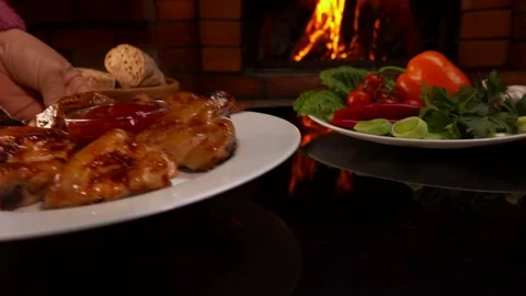 Hand put on the table a plate of fried chicken wings Stock Footage 70469273