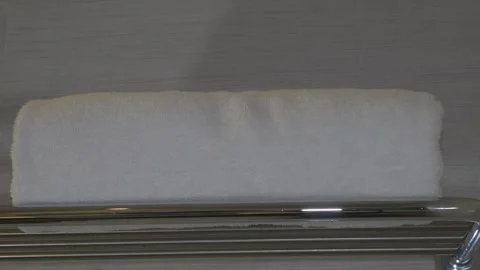 Hand put a towel on a bathroom hotel shelf Stock Footage 242901432