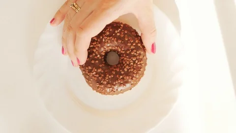 Hand puting tasty chocolate donut with sugar sprinkle on white plate 스톡 동영상 124461661