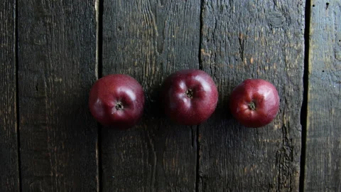 Hand puts apples on wooden background Stock Footage 106936404