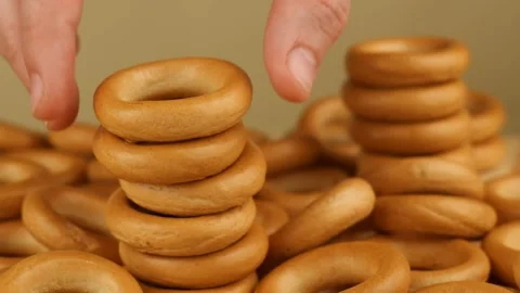 Hand puts a bagel 스톡 동영상 186943712