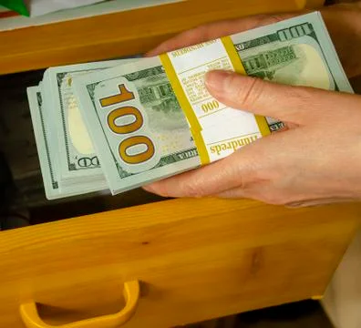 The hand puts the banknotes in the drawer of the table. 1 Foto stock