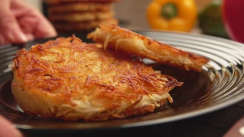 Hand puts a black plate with fried potato pancakes on the table Stock-Footage 236494752
