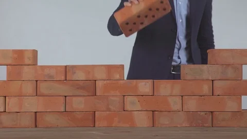 Hand puts the brick into the wall Stock Footage 81555938