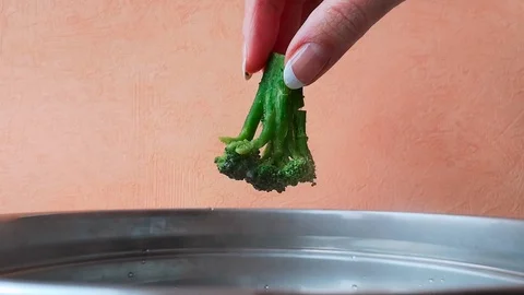 Hand puts broccoli in the pan Stock Footage 103836015