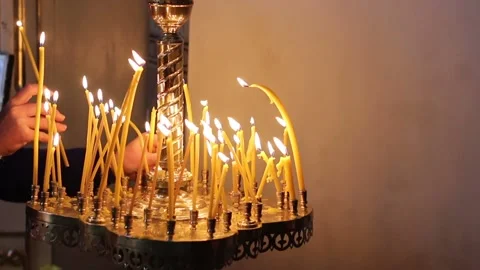 Hand puts a burning candle in the Orthodox Church Vídeos de archivo 112104701