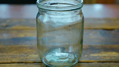 Hand puts cash dollars in a glass jar.closeup. Stock Footage 102760962