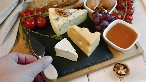 Hand puts cheese knife on the table with cheese Stock Footage 145760673