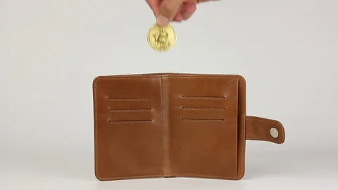 Hand puts coin bitcoin in light brown leather purse, loop video,white background 動画素材 92483139