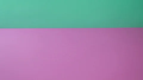 Hand puts convolute tablets on pink and green background. Stockbeeldmateriaal 126664128