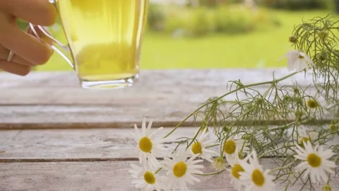 Hand puts a cup of chamomile tea Stock Footage 137785987