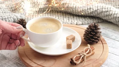 Hand puts cup of coffee on table. Close-up, slow motion. Cozy autumn composition Stock Footage 165336742