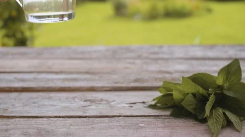 Hand puts a cup of mint tea Stock Footage 137783840
