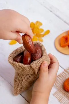 Hand puts dates in burlap bag, sackcloth and dried fruits. Eco and zero waste Stock Photos