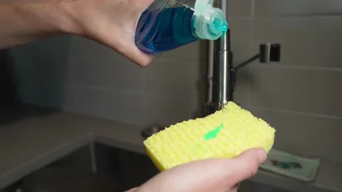 Hand puts dish soap on sponge Stock Footage 156222999