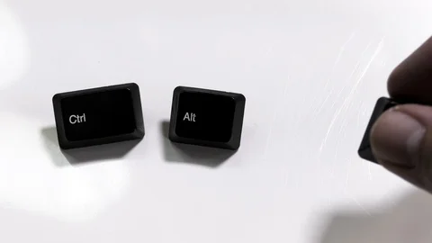 Hand puts down Ctrl, Alt, Delete keys on white table Stock Footage 100555410