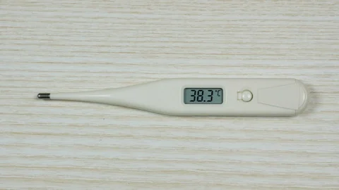 Hand puts an electronic thermometer with a high temperature indicator Video stock 125982459