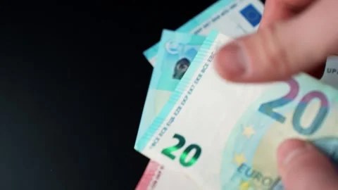 Hand puts euro banknotes on a dark table with copy space, illustrating cash Vidéo 331107953