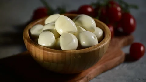 A hand puts the fresh basil leaf on a bowl with mozzarella cheese Stock Footage 153310817