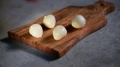 A hand puts the fresh small ball of mozzarella on a cutting board Stock Footage 153311343