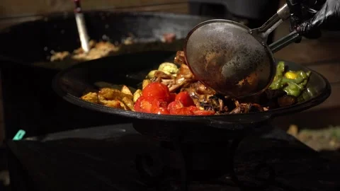 Hand puts grilled meat and grilled vegetables on a plate at a street food Stock-Footage 244815446