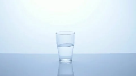 Hand puts half full glass of water on the table, middle Stock Footage 11611127
