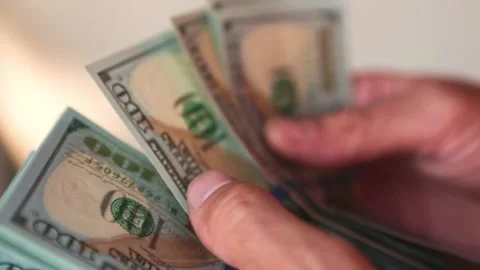 Hand puts a hundred-dollar bill in a pile and takes a banknote. Stock Footage 167990417