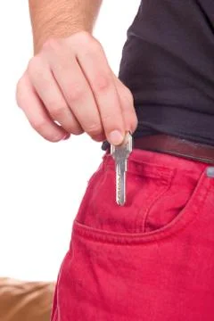 Hand puts the key in pocket Stock Photos