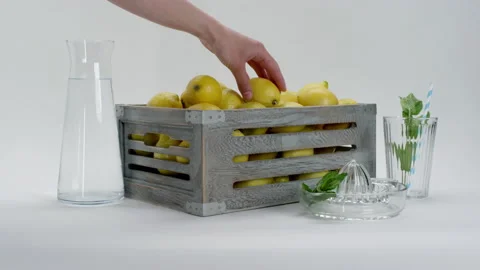 Hand puts lemon in to the basket full of lemons Stock Footage 169816089