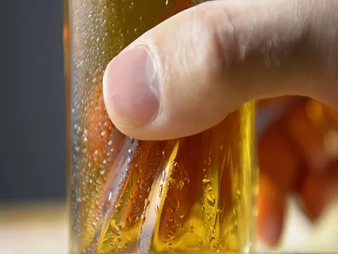 Hand puts a misted glass of cold light beer on a black background. Stock Footage 121252048