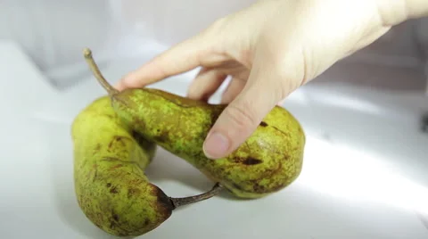 A hand puts a pear on the scene. Fruit Still Life in a white box. Stock Footage 61332765