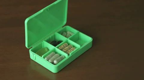 Hand puts pills in a container for tablets Stock Footage 61841167